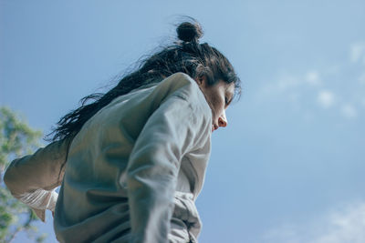 Low angle view of woman standing against sky