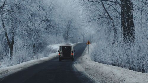 Car on road in forest during winter