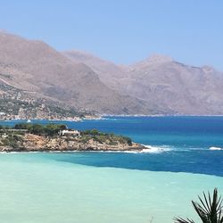 Scenic view of lake and mountains against clear blue sky