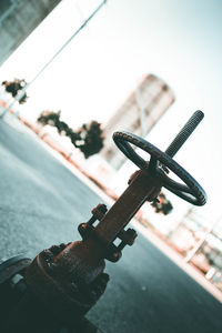 Close-up of bicycle wheel against sky in city