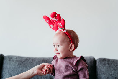 Cute smiling baby girl sitting on sofa at home