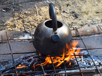 High angle view of kettle over fire at field