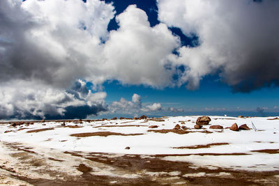 Scenic view of snow covered landscape against blue sky