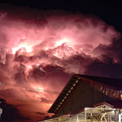 Low angle view of illuminated building against sky at night