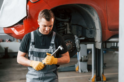 Man in uniform is in the auto service.