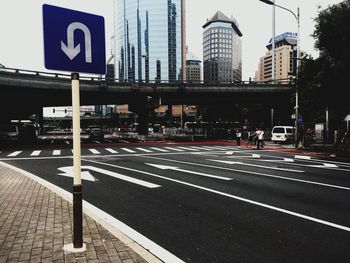 Road sign against buildings in city