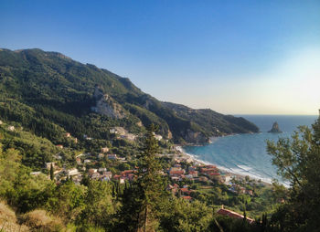 Scenic view of sea and mountains against clear sky