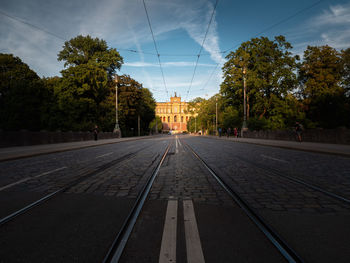 Surface level of railroad tracks in city against sky