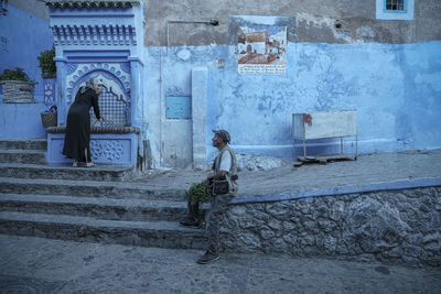 Side view of people walking on staircase outside building