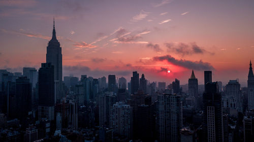 Aerial view of cityscape against cloudy sky
