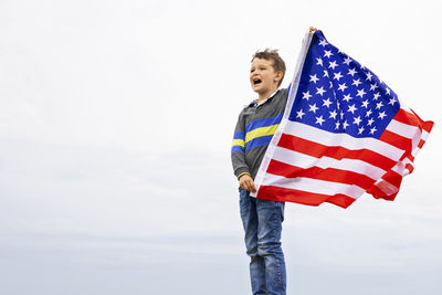 Low angle view of american flag against sky