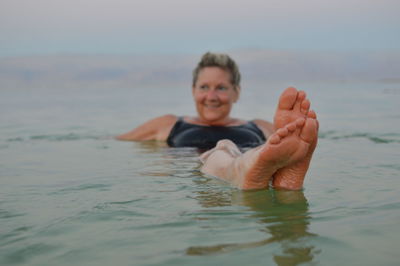 Portrait of young woman swimming in sea
