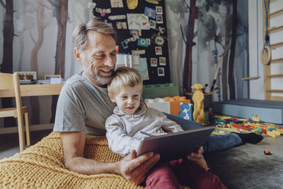 Father and son sitting on laptop