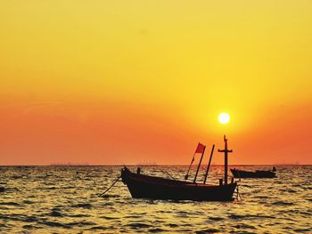 Boat in sea against sky during sunset