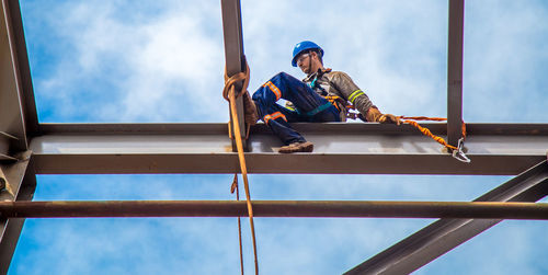 Low angle view of manual worker working at construction site