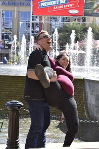 Mother and son standing on sidewalk in city