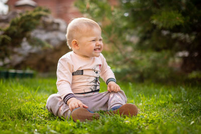 Cute girl laughing while sitting on grass