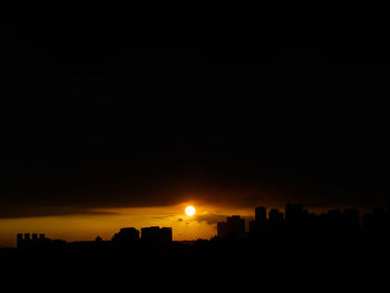 Silhouette buildings against sky during sunset