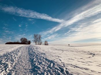 Scenic view of snow covered field against sky