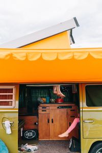 Yellow bus on car against sky