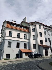 Building by road against sky in city