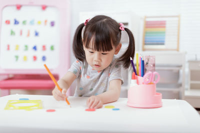 Cute girl sitting on table