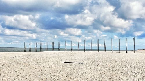 Scenic view of beach against cloudy sky