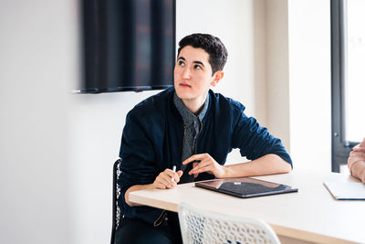 Young businessman concentrating while sitting at table during meeting at office