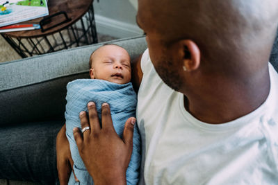 Newborn baby sleeping in fathers arms