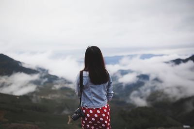 Rear view of woman standing against mountain