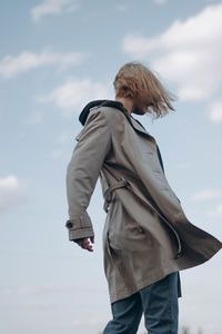 Low angle view of woman standing against sky