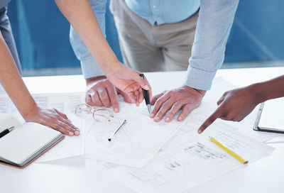 Midsection of business people working at table