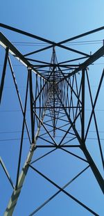 Low angle view of electricity pylon against clear sky