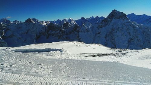 Scenic view of snowcapped mountains against clear sky