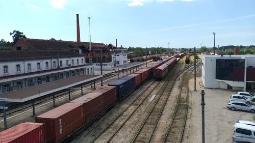 Train at railroad station in city against sky