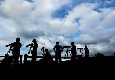 Silhouette people standing against sky