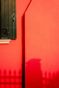Detail of red colored houses with burano window with shadow