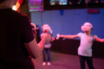 Vr game and virtual reality. team family dad and kids gamers fun playing on futuristic simulation