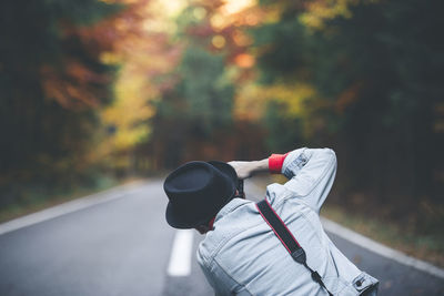 Rear view of young woman standing on road