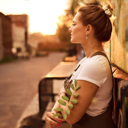 Portrait of a happy beautiful young girl at sunset in urban background