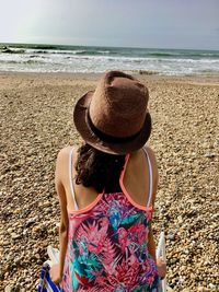 Rear view of woman wearing hat on beach