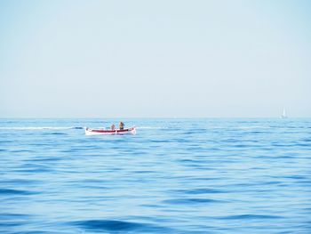 People in sea against sky