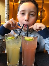 Close-up portrait of boy drinking juices at restaurant