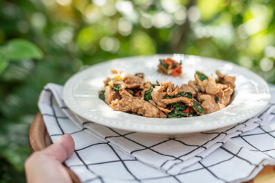 Close-up of person preparing food in plate on table