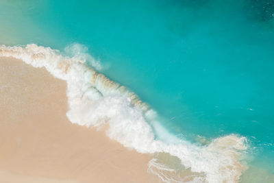 Aerial view of wave splashing at shore