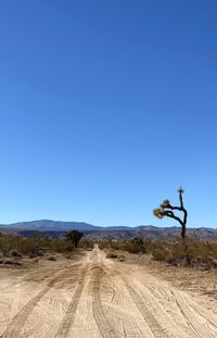 Scenic view of desert against clear blue sky