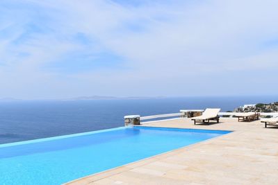 Swimming pool by sea against sky