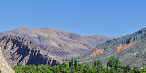 Scenic view of mountains against clear blue sky