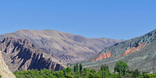 Scenic view of mountains against clear blue sky