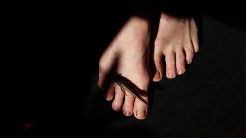 Close-up of hands against black background